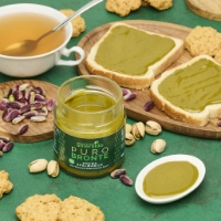 Crema Dolce Spalmabile Con Pistacchio Verde Di Bronte Dop al 75%, vista frontale sfondo te caldo
