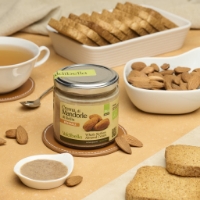 Crema di Mandorle Integrale e Senza Zucchero, inclinata a dx con mandorle e sfondo pane
