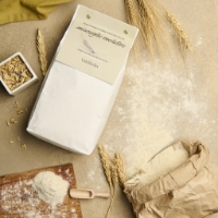 Farina Bio di Grano Tenero Miscuglio Evolutivo, dall'lato con farina sciolta e cestino di carta