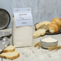 Farina Integrale Bio di Grano Tenero Maiorca, inclinata a dx con ciotola, sfondo pane