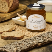 Il delicato Miele del Piemonte, sfondo pane su tovaglietta paglia