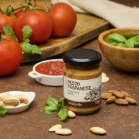 Pesto Trapanese Bio, vista frontale con ingredienti su tavola di legno