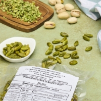 Pistacchio Di Bronte Dop Pelato Extra 100g, dall'alto inclinazione a sx, su tavola verde