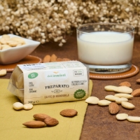 Preparato per latte di mandorla, frontale con bicchiere latte sfondo