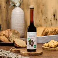 Sciroppo carrube vista frontale, sfondo filone pan carrè