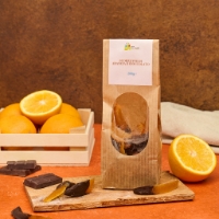 Scorzette arancia al cioccolato, vista frontale su tagliere legno e arance