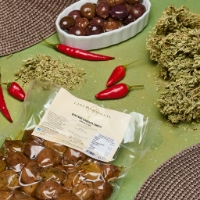 Olive Giaraffa condite, vista dall'alto, inclinata a sx con peperocino e contenitore