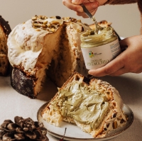 Fetta di panettone posta su un piatto mentre viene farcita di crema al pistacchio